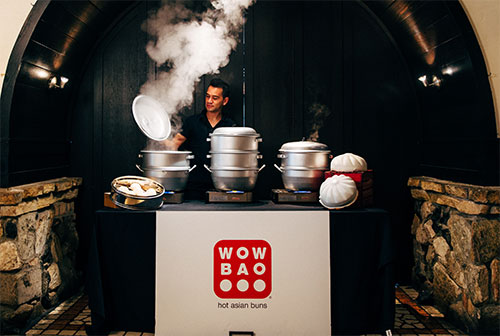 man cooking at a table with steam flying up around him